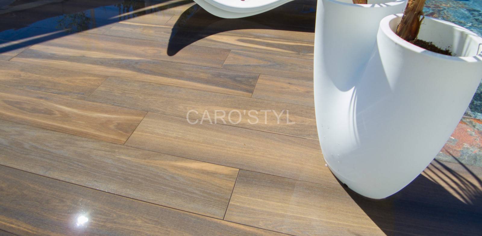 Terrasse extérieure à La Seyne-sur-Mer en carrelage Allure Noce Brun Italgraniti autour d’une piscine moderne.