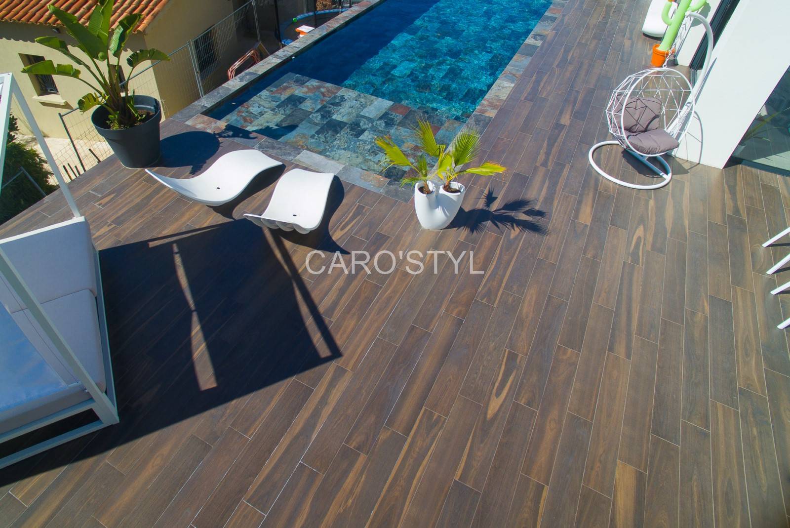 Plage de piscine design à Toulon avec carrelage imitation bois Allure Noce Brun posé en lame droite.