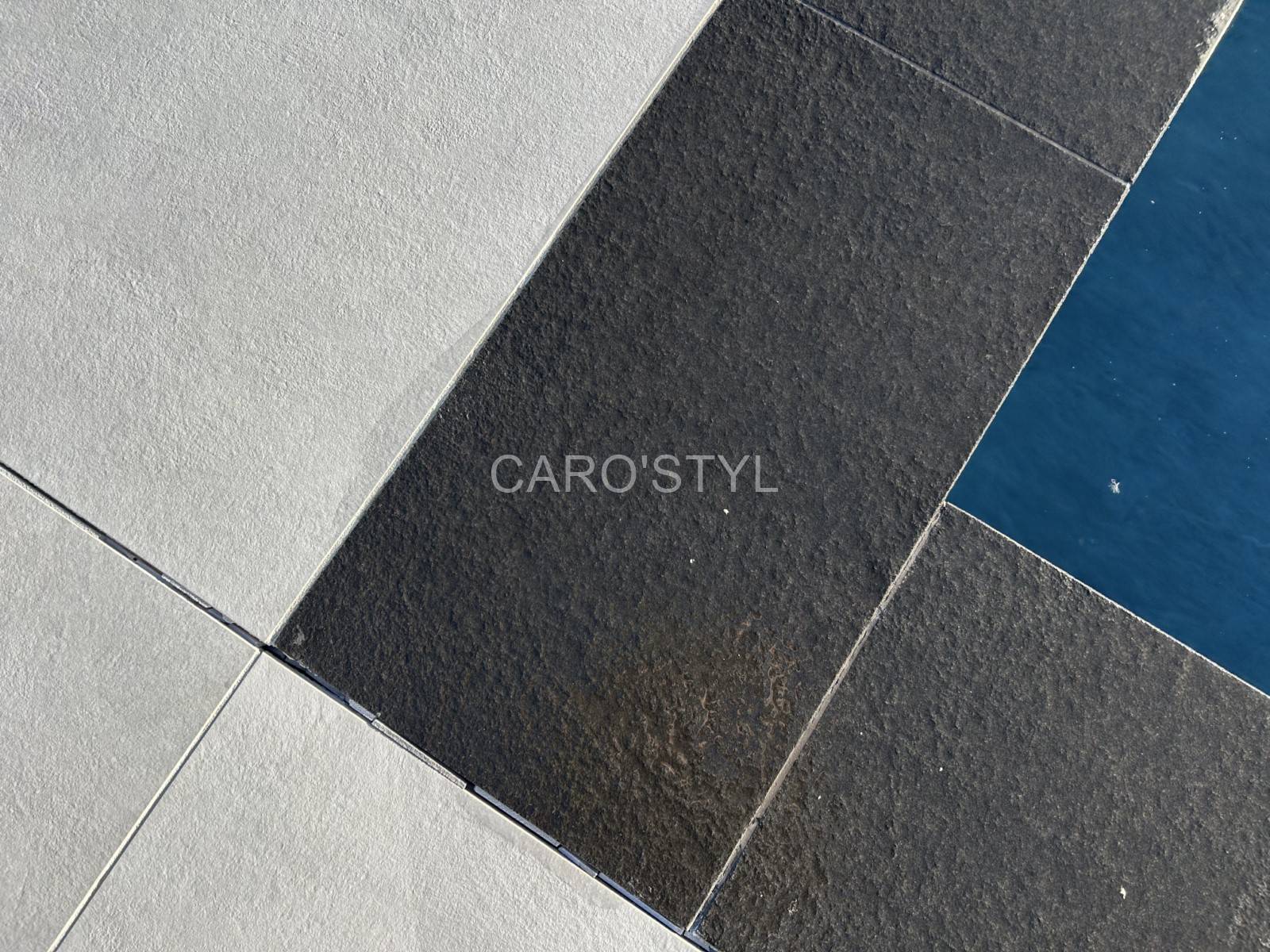 Détail de margelle Black Basalt sur piscine miroir moderne située à Bandol