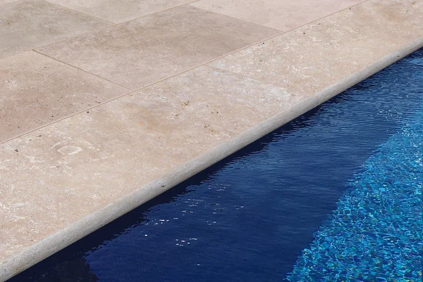 rebord de piscine en travertin demi-rond 3 cm finition arrondie sécurisante pierre beige