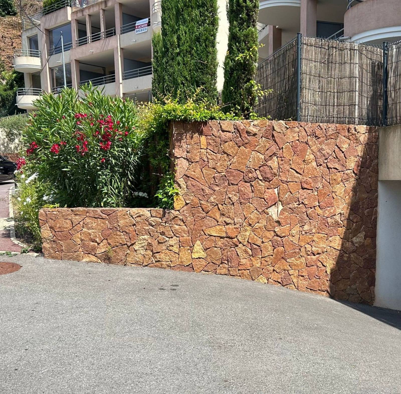 Mur extérieur en parement Esterel rouge à Toulon, pierre naturelle effet roche méditerranéenne.